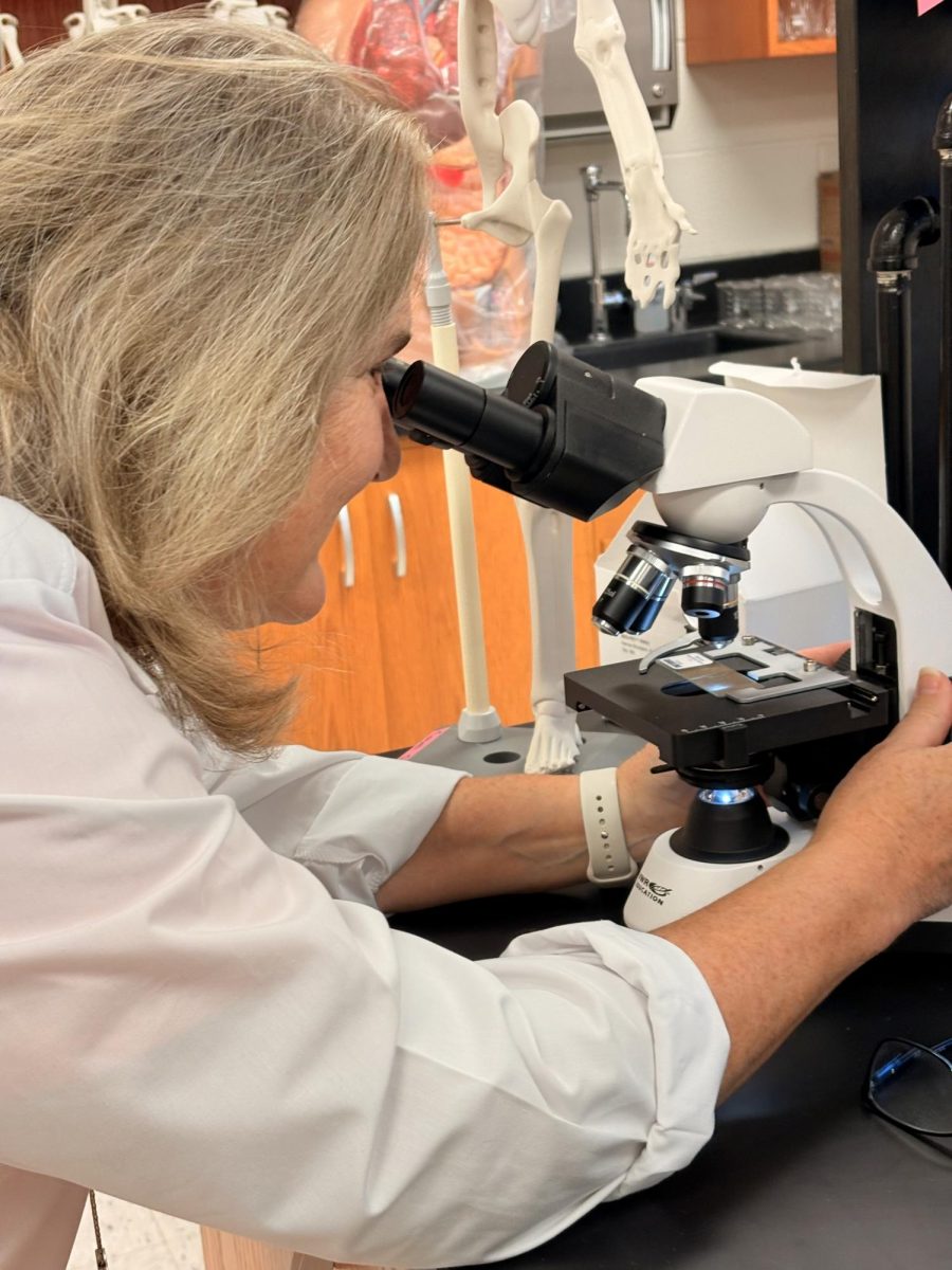 Dr. Swanchara, head of HAMSci program, looking through a microscope