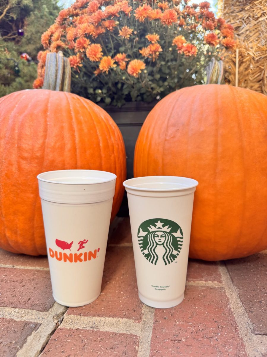 Two coffee cups- one from Dunkin and one from Starbucks- surrounded by fall decor 